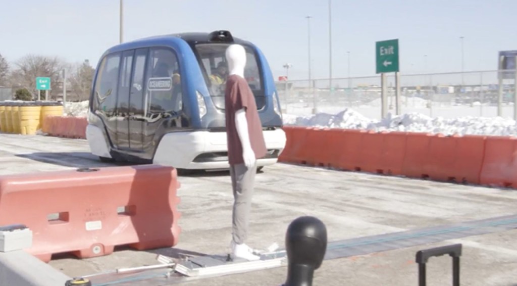A self-driving bus approaches a mannequin in a demonstration of its ability to detect pedestrians.
